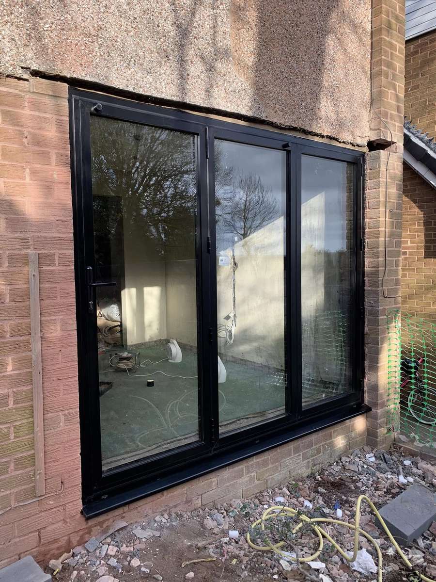An anthracite aluminium bifold door set opening onto a patio