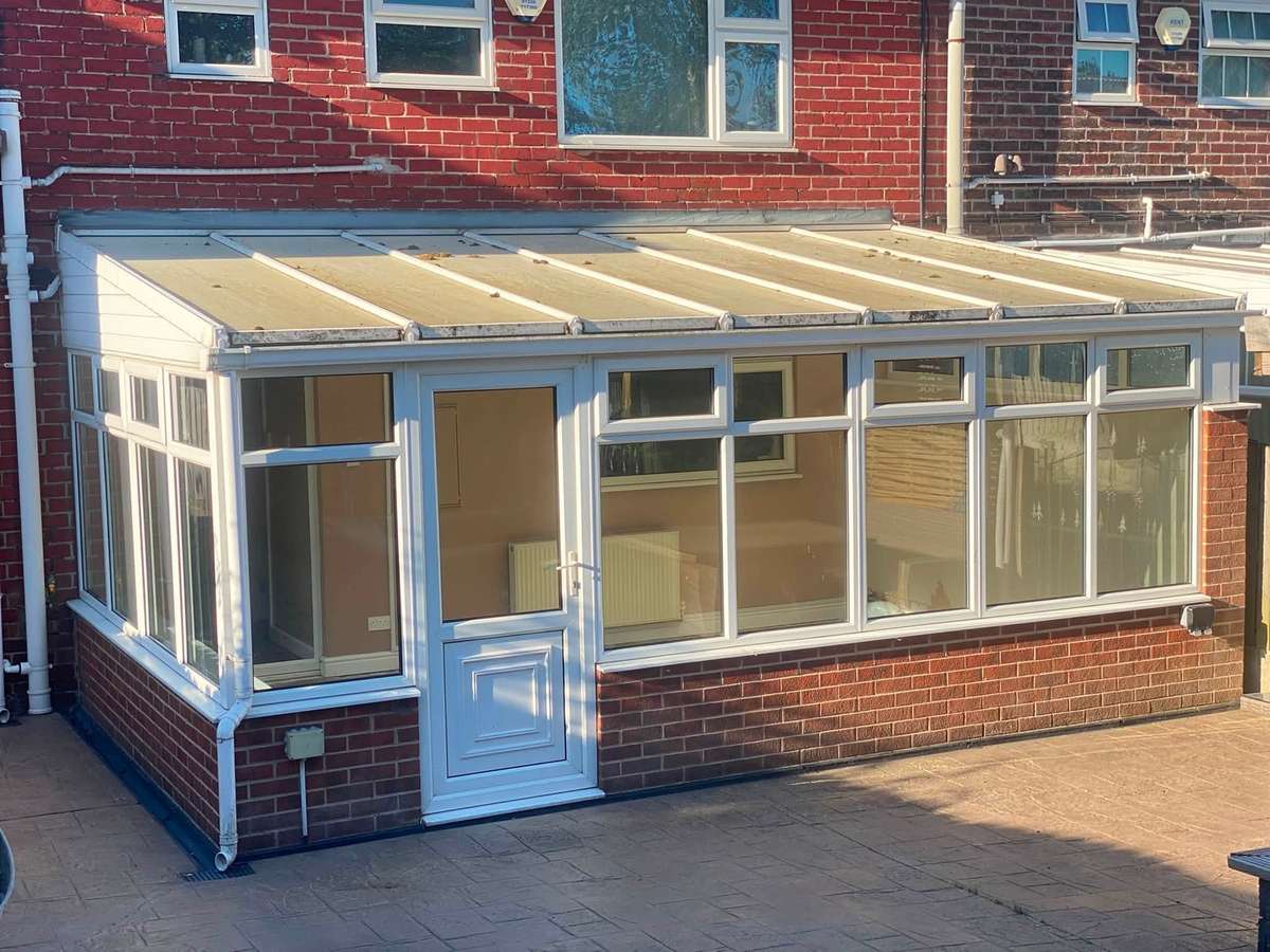 A garden room with a glazed lantern roof at the end of a patio